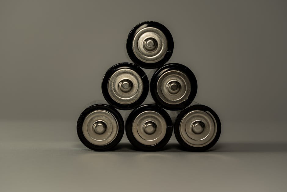 Metallic AA batteries stacked in a pyramid shape, symbolizing power and energy storage. — Photo by Castorly Stock on Pexels