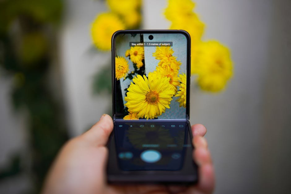 A smartphone capturing vivid yellow flowers, showcasing technology and nature interaction. — Photo by Imad Clicks on Pexels